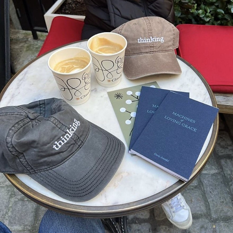 Embroidered caps and notebooks on a café table